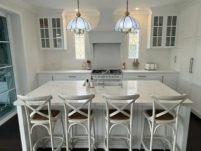 Hamptons style kitchen with shaker cabinetry and glass display doors