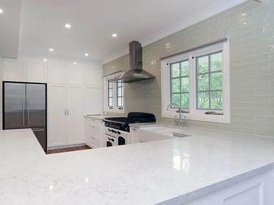 White shaker kitchen with green subway tile splashback